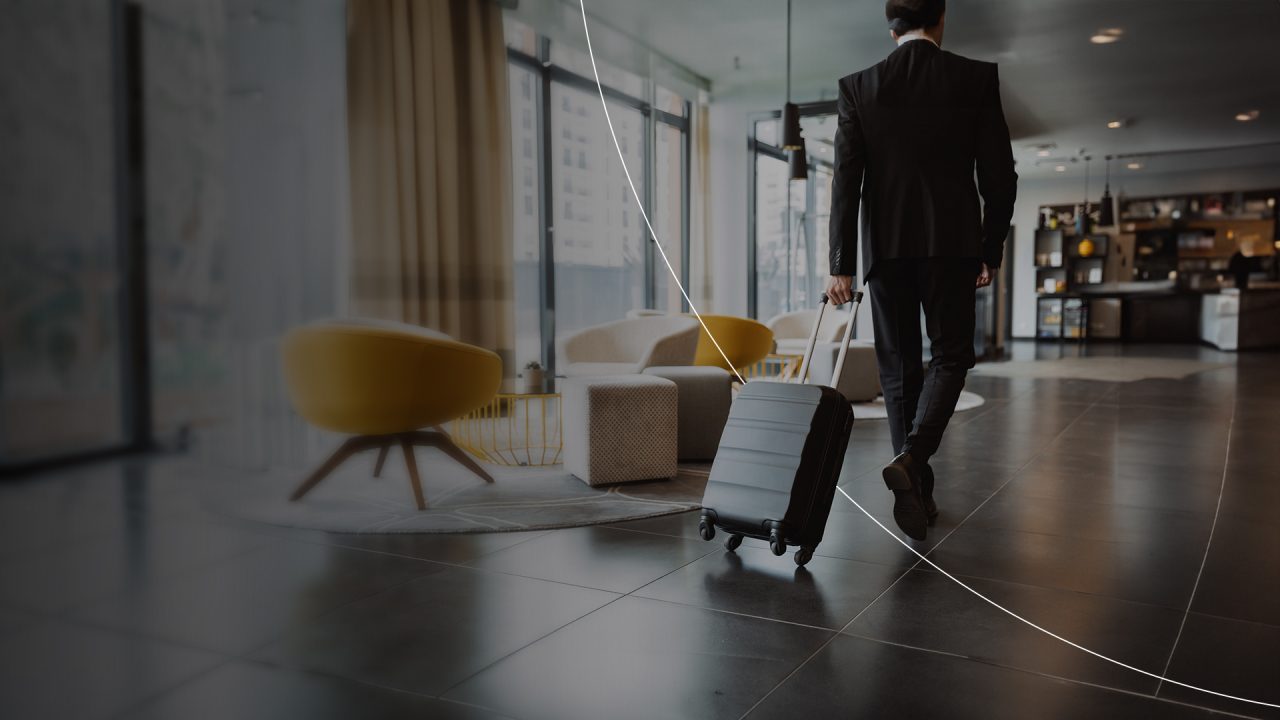 Businessman with luggage walking in airport desktop banner.