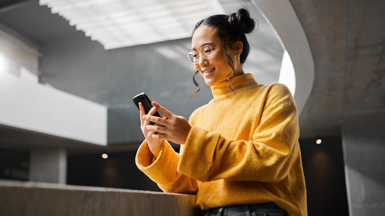 Woman using phone in modern office.