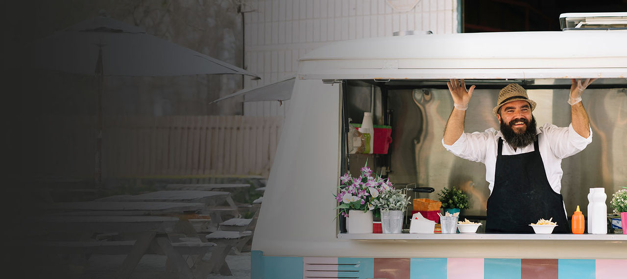 Food truck operator smiling in his truck.