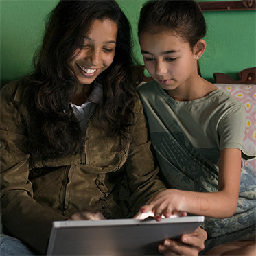 Mom checking mobile device with daughter.