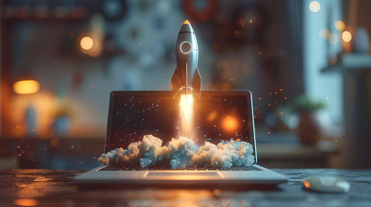 Toy rocket taking off from a laptop.