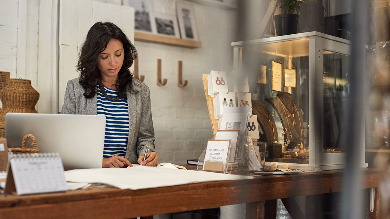Woman merchant doing paperwork in her boutique