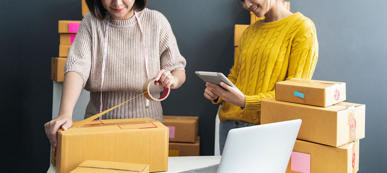 Women packing boxes together for shipment