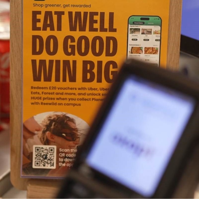 A placard reading Eat Well Do Good Win Big next to a point of sale device. 