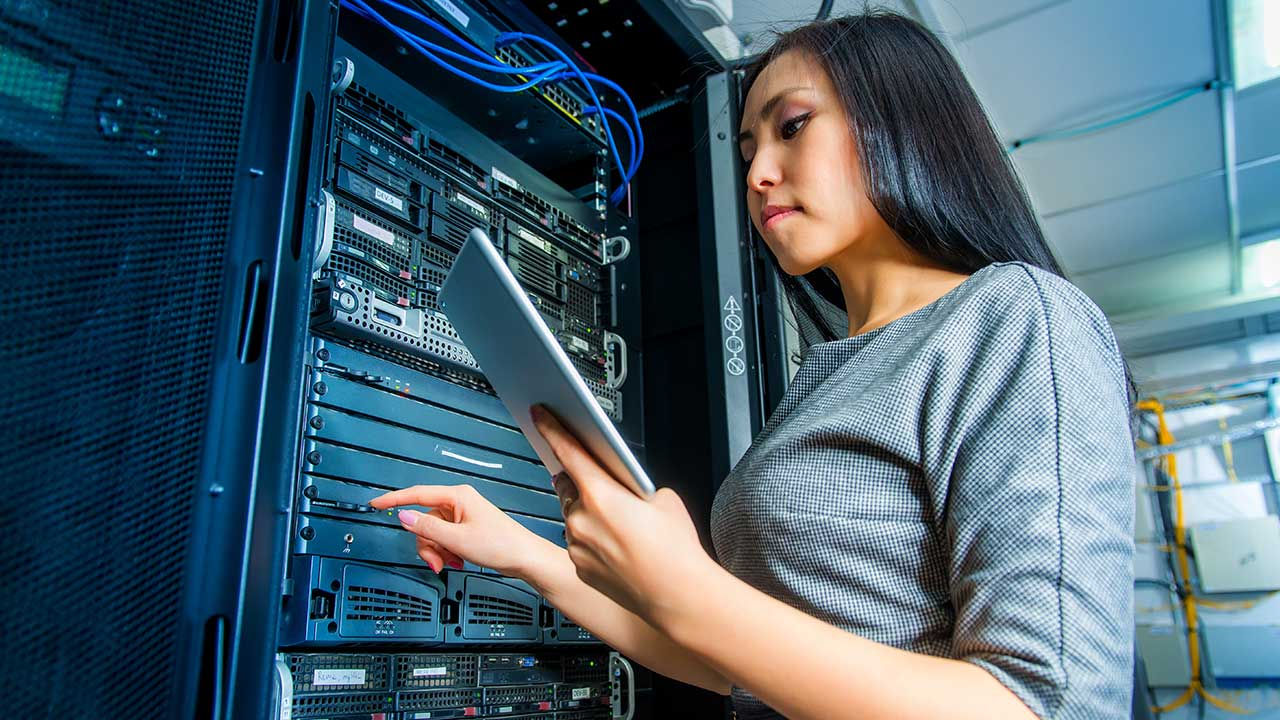 Mujer de negocios ingeniera en sala de servidores de red.