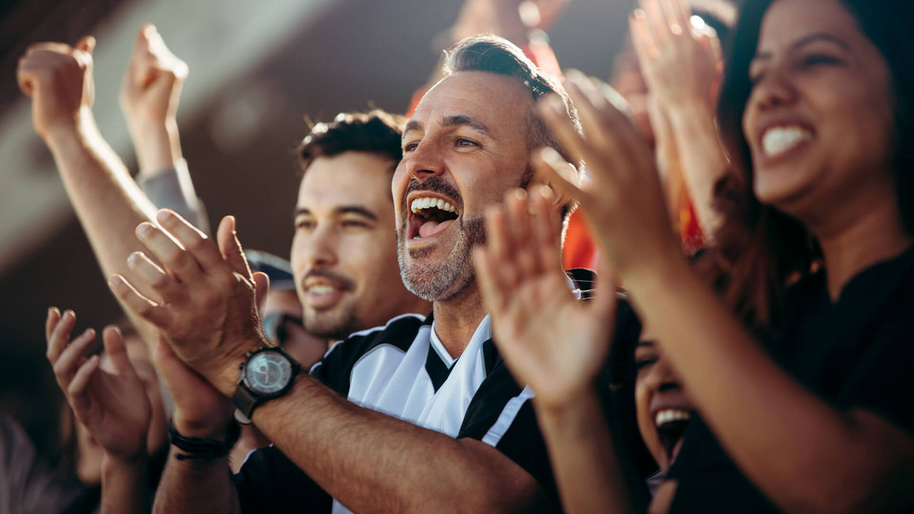 Aficionados disfrutando de un partido en un estadio.