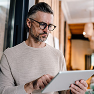 White middle aged man using tablet computer while working in office.